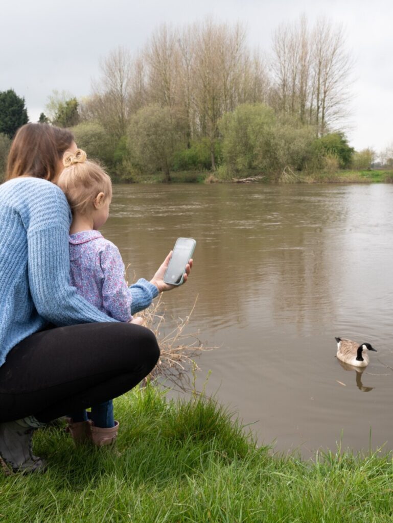 Mum and daughter using the Planet Patrol app by water